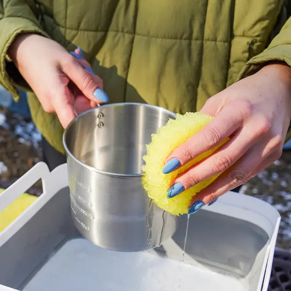 Yellow Scrub Daddy essentials cleaning outside of a dirty cup